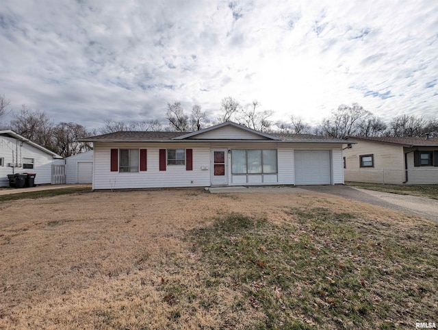 ranch-style house with a front lawn, a garage, and driveway