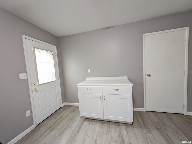 interior space with baseboards and light wood-type flooring