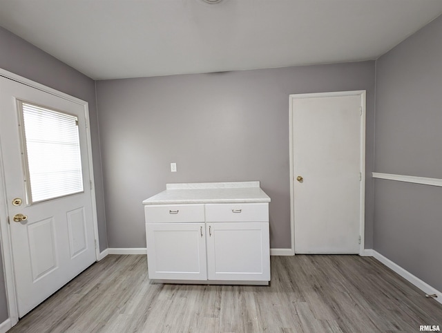 interior space featuring light wood-type flooring and baseboards