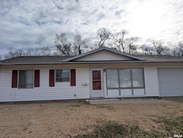 ranch-style house featuring an attached garage, a front lawn, and roof with shingles