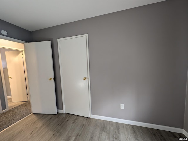 unfurnished bedroom featuring baseboards and wood finished floors