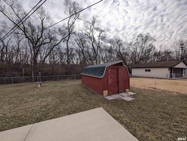 view of yard with an outdoor structure, a storage unit, and a fenced backyard