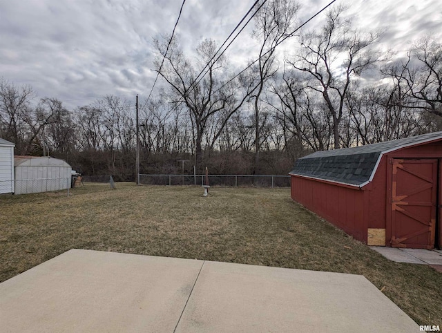 view of yard with an outbuilding, a storage shed, a patio, and fence