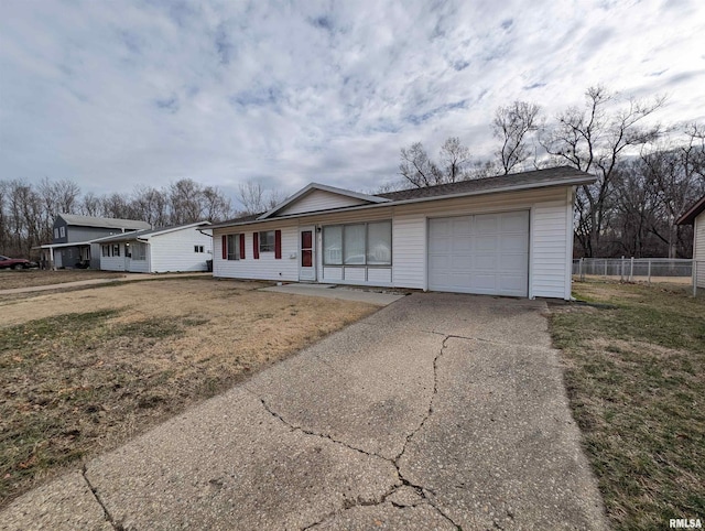 ranch-style home with a front lawn, concrete driveway, a garage, and fence