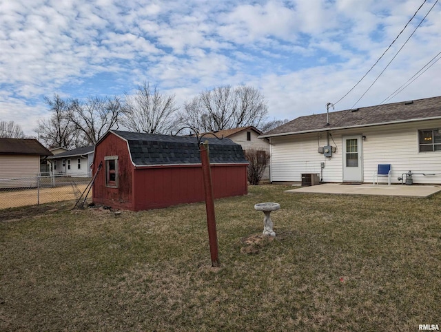 view of yard with a patio, an outbuilding, fence, central AC, and a storage unit