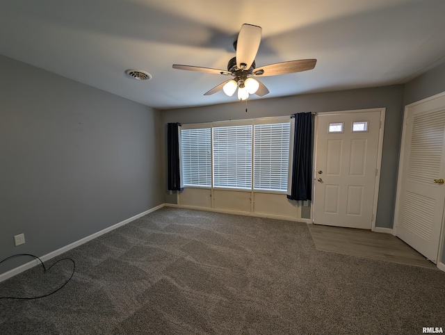 interior space with visible vents, baseboards, carpet, and a ceiling fan