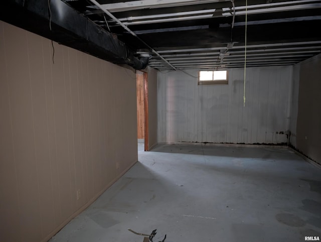 basement featuring wood walls