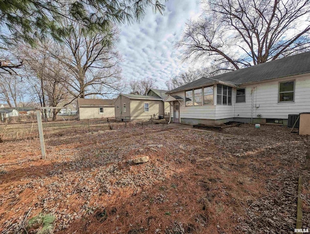 view of yard with central AC unit and fence