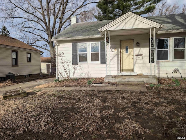 bungalow-style home with central AC and a chimney