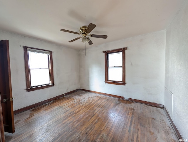 unfurnished room with visible vents, baseboards, a ceiling fan, and hardwood / wood-style floors