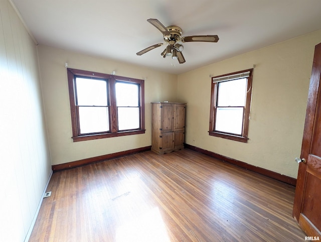 unfurnished room with baseboards, light wood finished floors, and ceiling fan