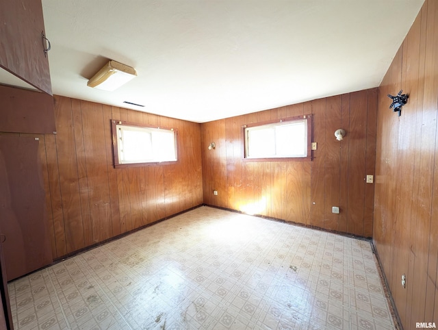 empty room with light floors and wooden walls