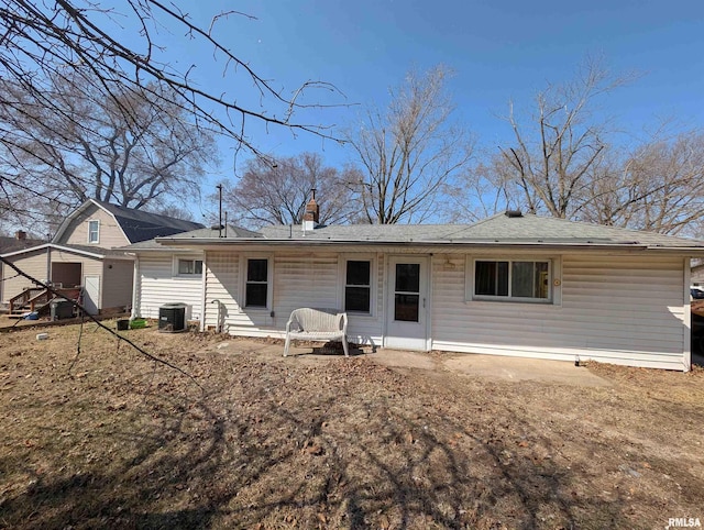 rear view of property with central AC and a chimney