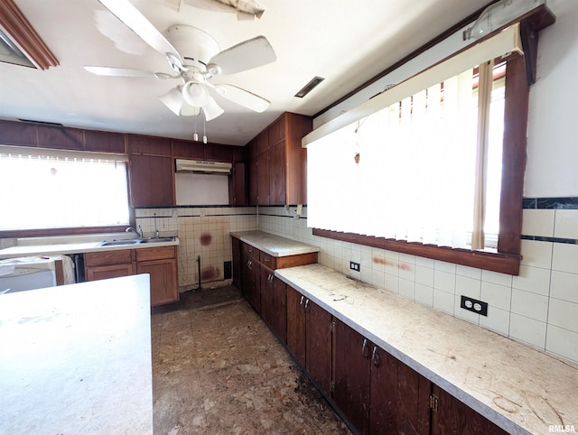 kitchen featuring visible vents, ceiling fan, light countertops, tile walls, and a sink