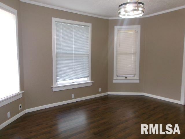 1209 S 4th St, Pekin, IL 61554 - spare room with ornamental molding, a chandelier, and dark wood finished floors