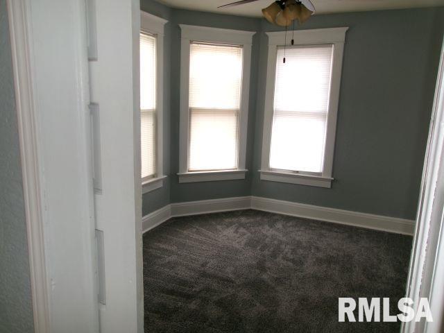 1209 S 4th St, Pekin, IL 61554 - spare room with dark carpet, healthy amount of natural light, and ceiling fan