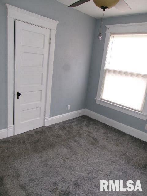 1209 S 4th St, Pekin, IL 61554 - empty room featuring a ceiling fan and dark carpet