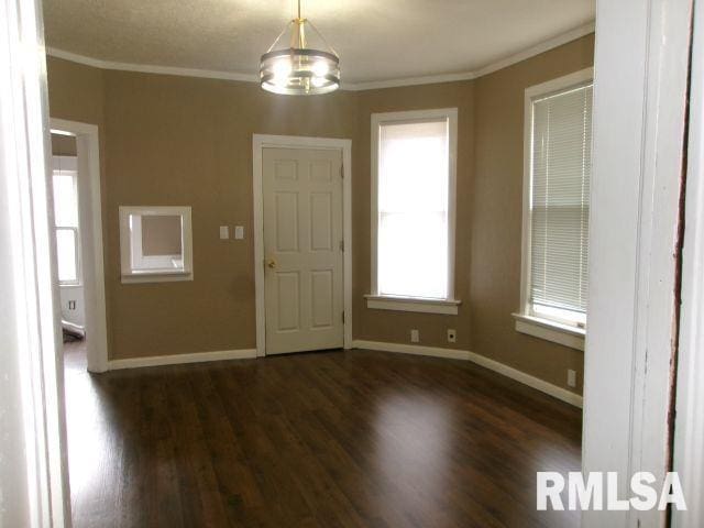 1209 S 4th St, Pekin, IL 61554 - unfurnished dining area featuring wood finished floors, crown molding, and a chandelier