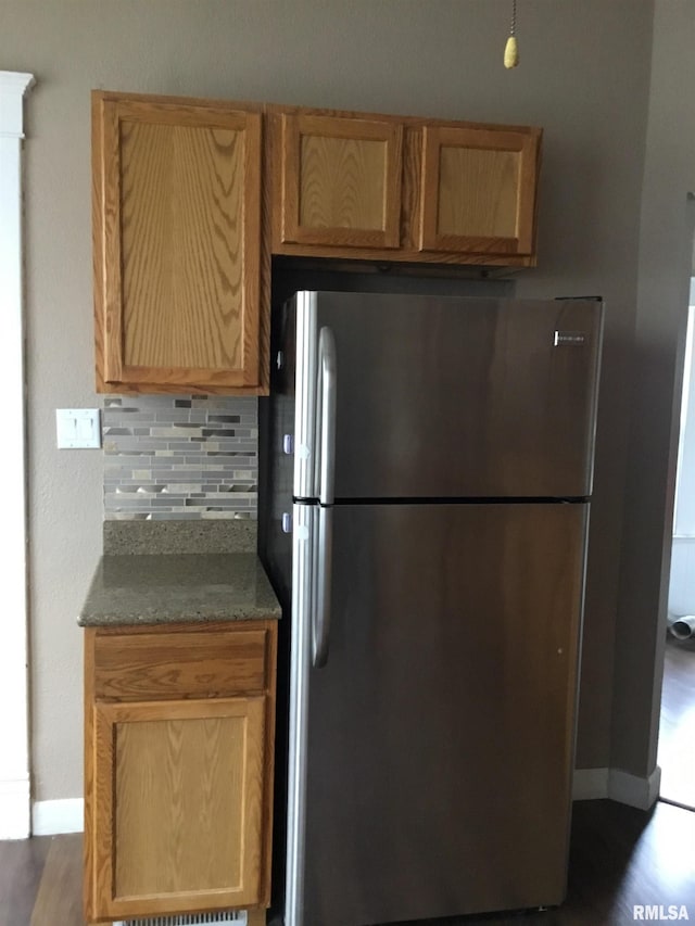 1209 S 4th St, Pekin, IL 61554 - kitchen featuring freestanding refrigerator, tasteful backsplash, dark stone counters, and dark wood-type flooring