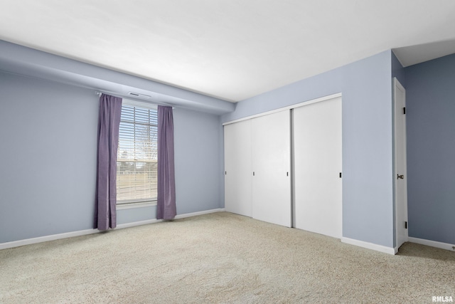 unfurnished bedroom with carpet floors, baseboards, a closet, and visible vents