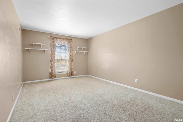 carpeted empty room featuring baseboards