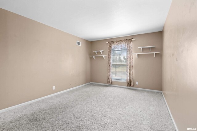 carpeted spare room featuring baseboards and visible vents