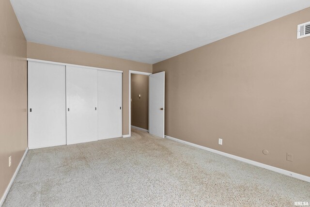 unfurnished bedroom with a closet, carpet flooring, and baseboards