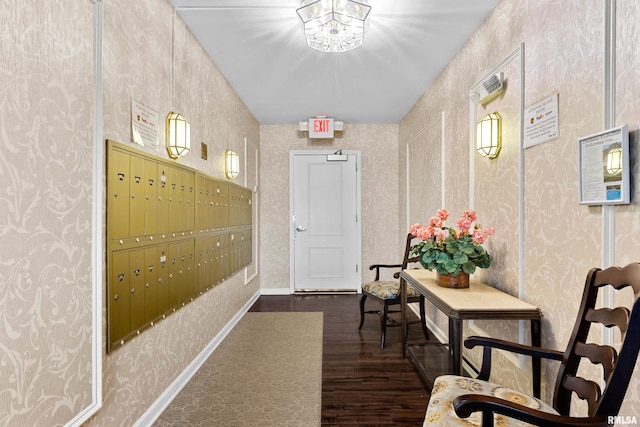 hall with wallpapered walls, wood finished floors, baseboards, and mail area