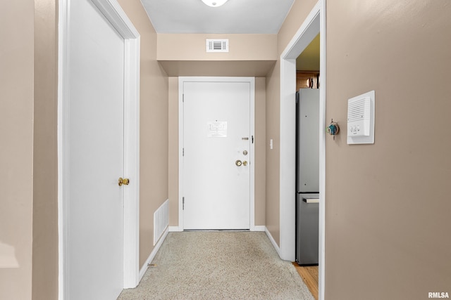 hall featuring baseboards and visible vents