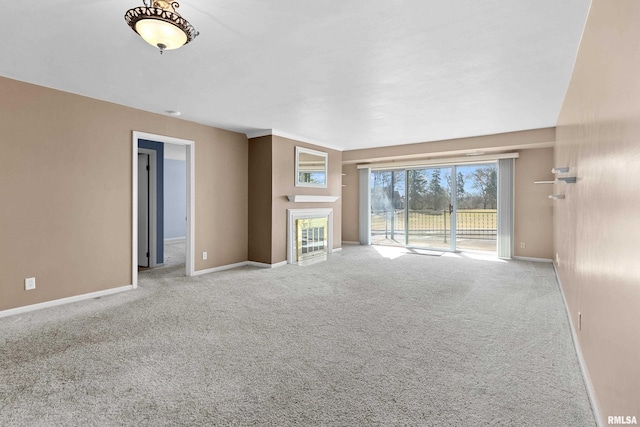 unfurnished living room with baseboards, a tile fireplace, and carpet flooring