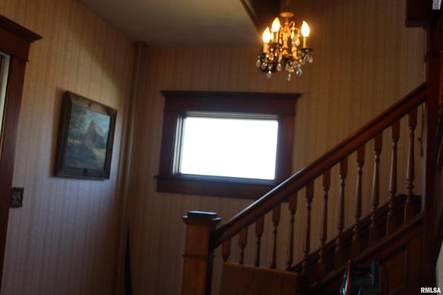 entryway featuring stairs, wallpapered walls, and a notable chandelier