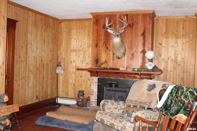 living room with wood walls, a baseboard radiator, a fireplace, wood finished floors, and ornamental molding