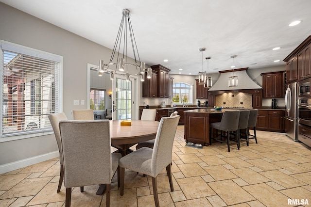 dining area featuring stone tile flooring, a notable chandelier, recessed lighting, and baseboards