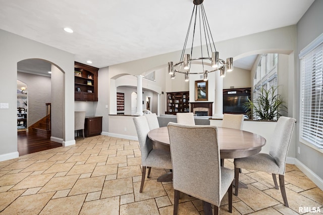 dining area with baseboards, ornate columns, recessed lighting, arched walkways, and stone tile flooring