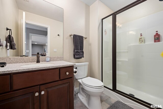 full bath featuring tile patterned flooring, a shower stall, toilet, and vanity