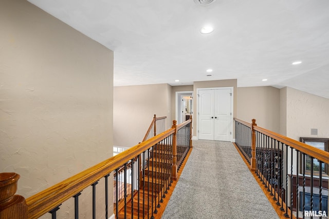 hallway with recessed lighting, an upstairs landing, carpet flooring, and a textured wall