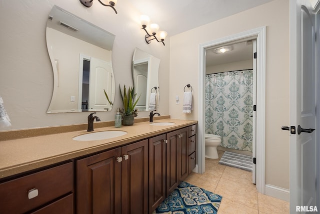 bathroom featuring double vanity, visible vents, toilet, and a sink