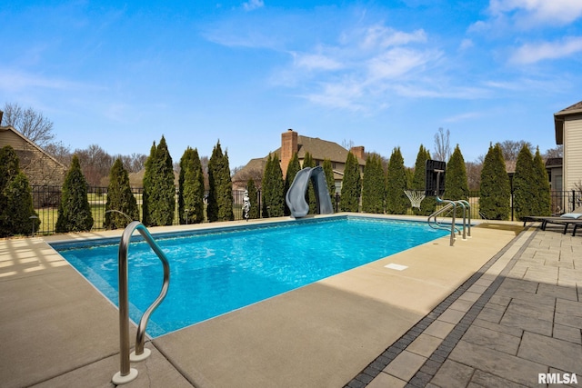 view of swimming pool featuring a patio area, a fenced in pool, a water slide, and fence