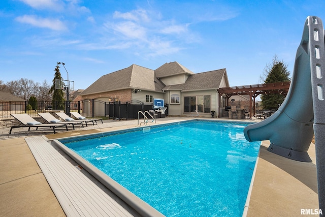 view of swimming pool featuring a fenced in pool, fence, a water slide, and a pergola