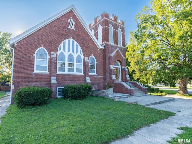 view of front of home with a front yard and brick siding
