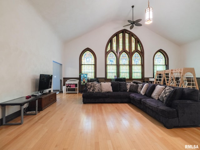 living area featuring a ceiling fan, plenty of natural light, high vaulted ceiling, and light wood-type flooring