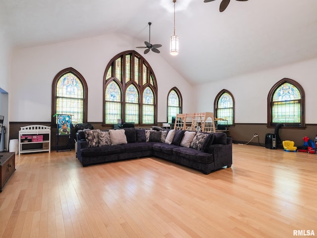 living area featuring light wood finished floors, high vaulted ceiling, and ceiling fan