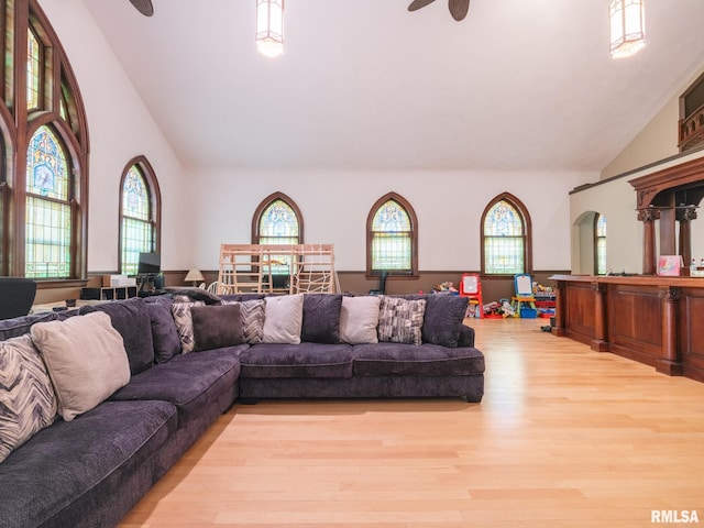 living room with light wood finished floors, high vaulted ceiling, and a ceiling fan