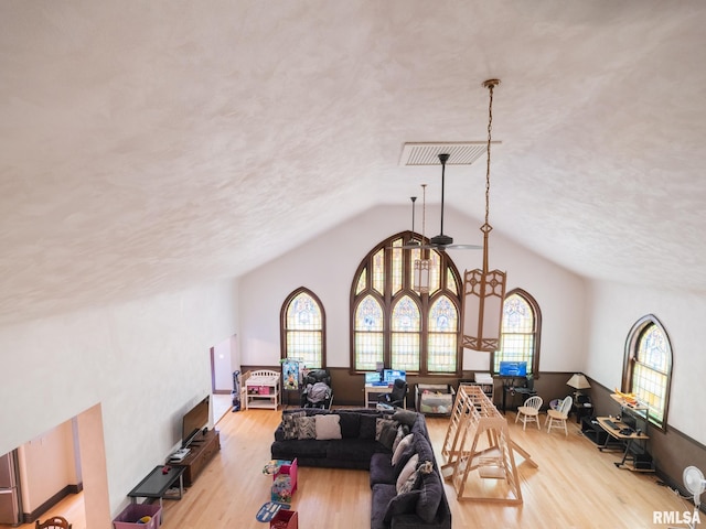 living area with a ceiling fan, lofted ceiling, and wood finished floors