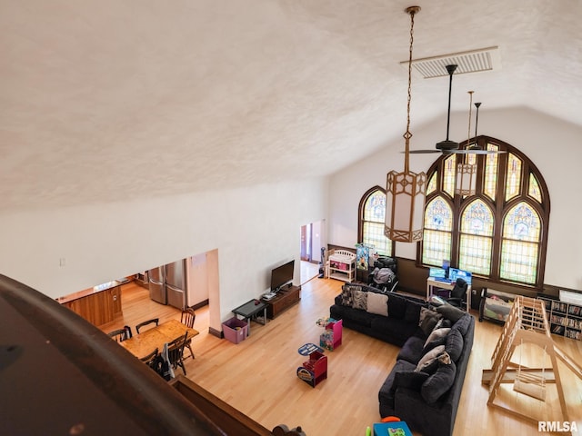 office area featuring light wood-style flooring, visible vents, lofted ceiling, and ceiling fan