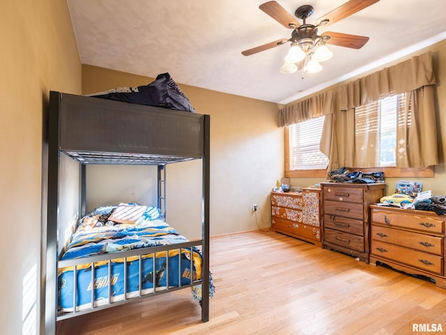 bedroom featuring baseboards, wood finished floors, and ceiling fan