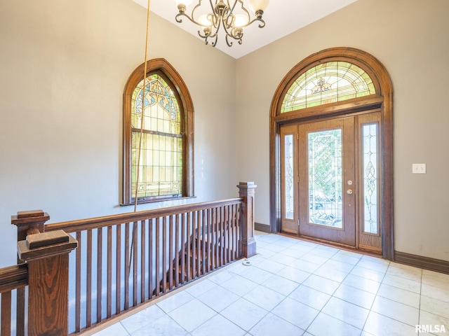 entryway with baseboards, a chandelier, and tile patterned floors