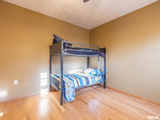 bedroom with baseboards and wood finished floors