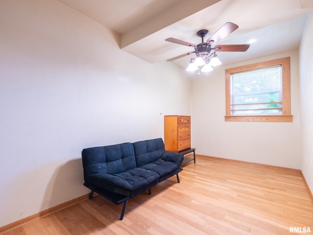 living area featuring baseboards, ceiling fan, and wood finished floors