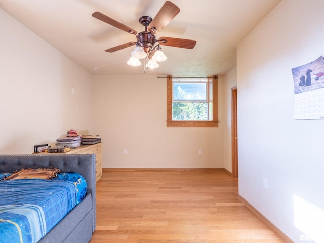 bedroom featuring baseboards, light wood-type flooring, and ceiling fan